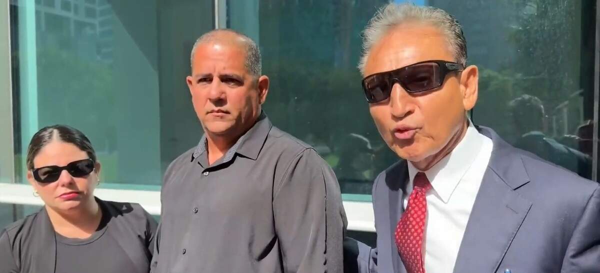 Yusiel Lopez Insua, center, stands with his attorney, Walter Reynoso, outside a federal courthouse in Miami on Tuesday, July 21, 2026. Lopez Insua faced 10 years in prison if convicted at trial.